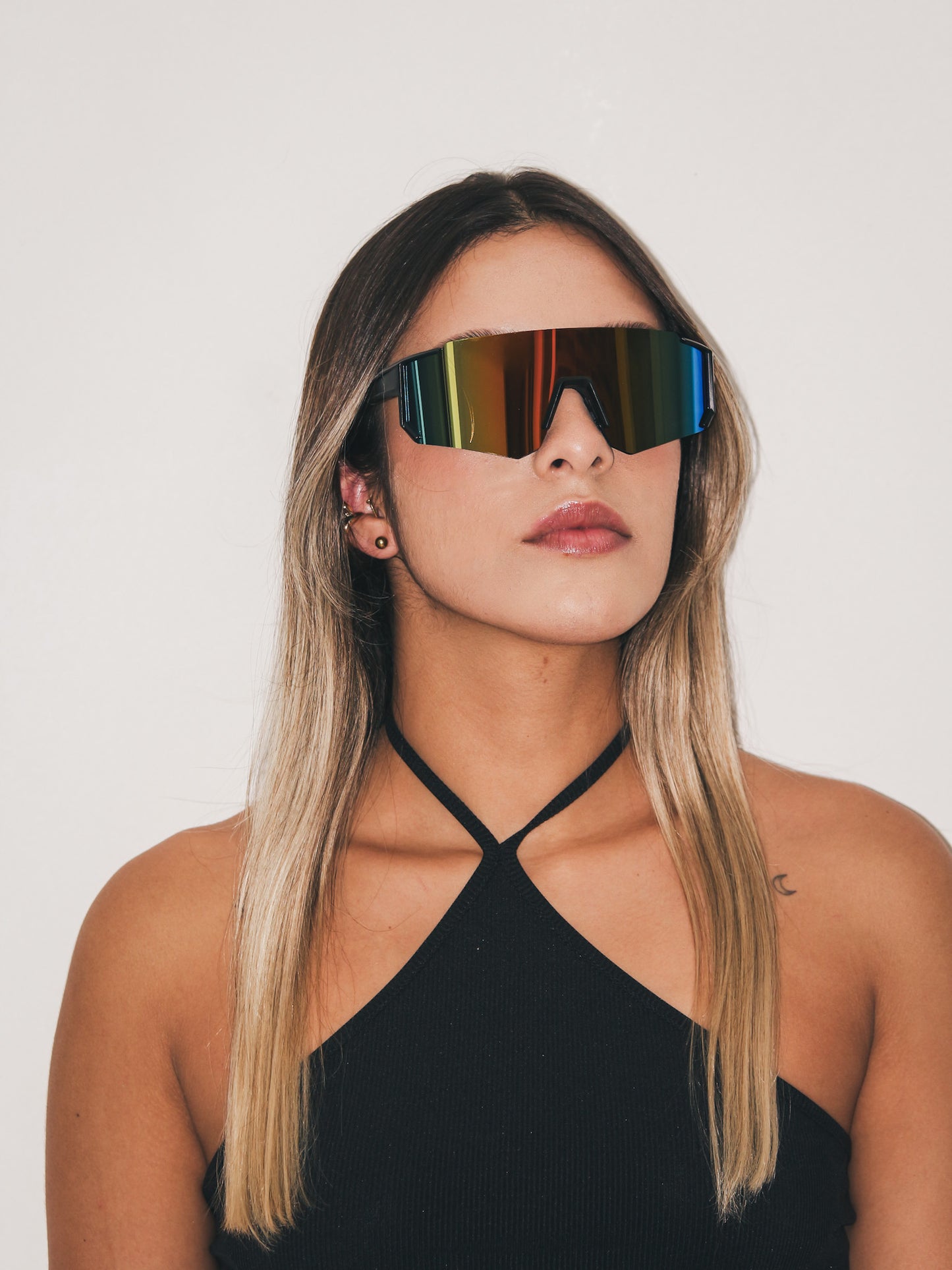 Gafas de sol estilo runner o cycling, marco color negro y lentes color holográfico.